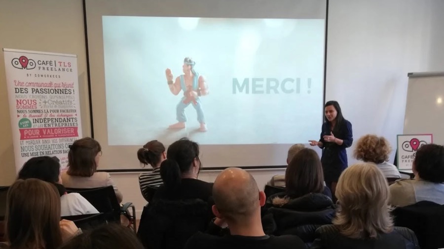 Soizic Fouilland sur scène devant l'écran « Merci ! », à côté du kakémono Café Freelance by Coworkees
